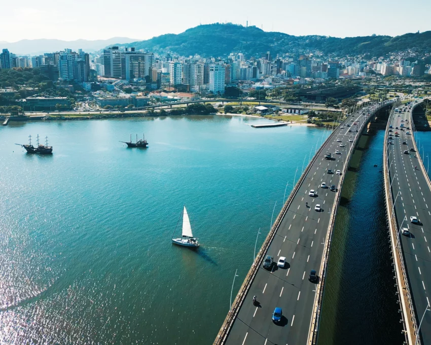 Imagem aérea da Ilha de Santa Catarina durante um dia ensolorado para ilustrar matéria sobre os melhores bairros de Florianópolis