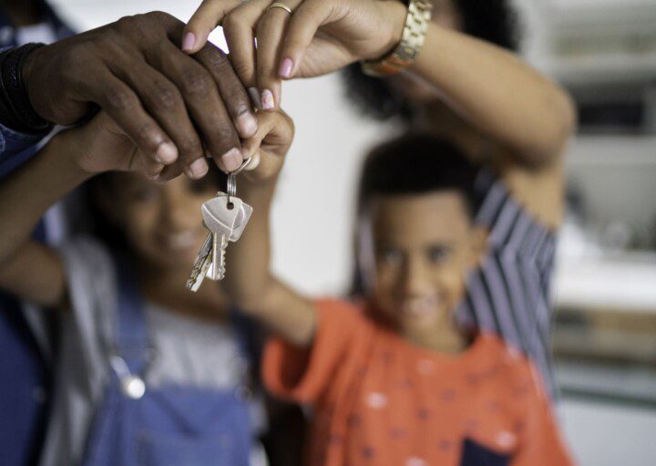 Família segurando as chaves do novo apartamento comprado na planta e decorado com todos os gostos da família