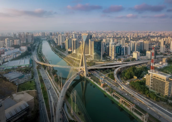 Imagem da vista aérea da Ponte Octavio Frias de Oliveira sobre o Rio Pinheiros ao pôr do sol em São Paulo para ilustrar matérias sobre os bairros mais caros de SP