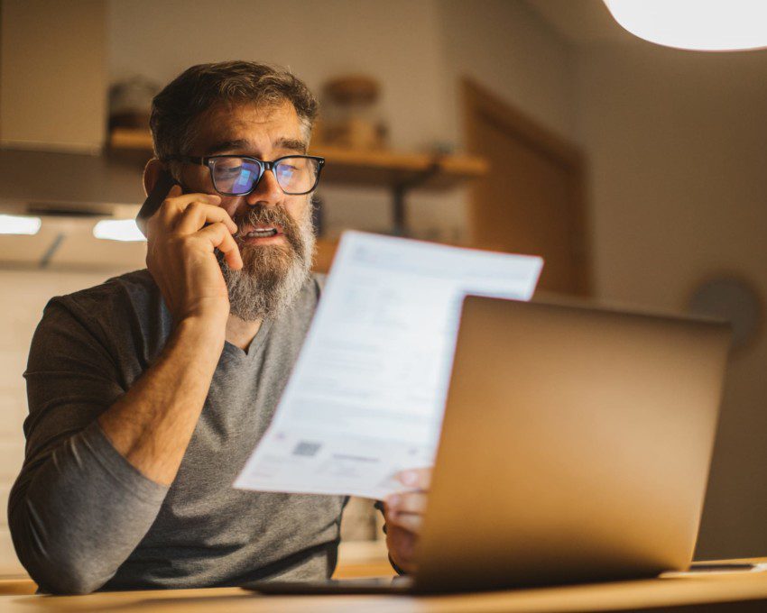 Em matéria que fala sobre aumento do gás, um homem está sentado com o telefone no ouvido e com um papel na mão, simulando o ato de estar falando sobre uma conta.