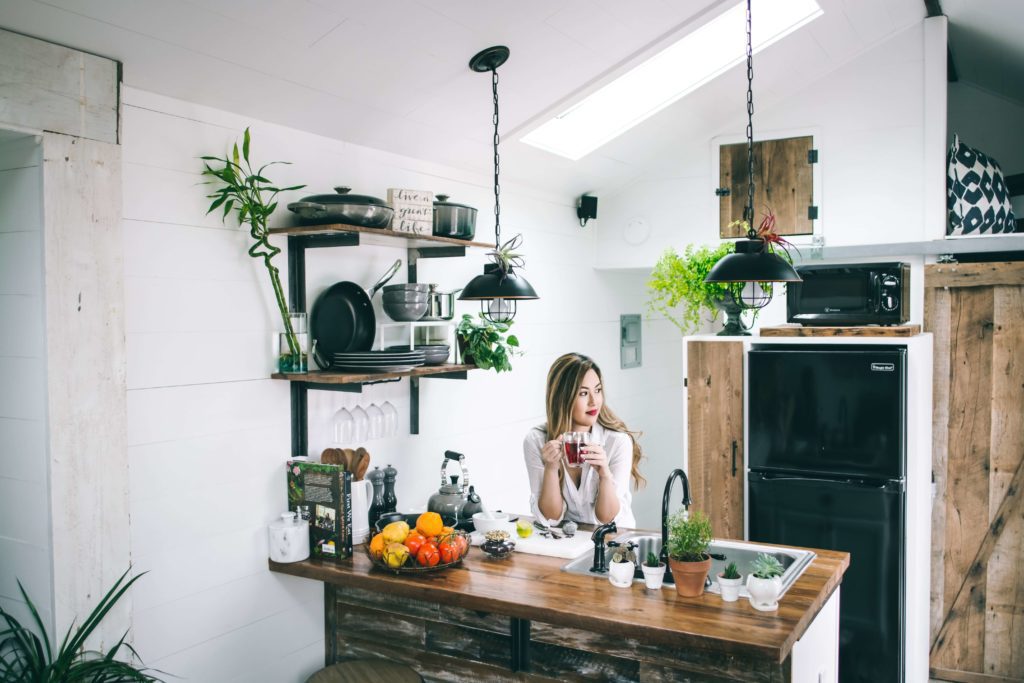 cozinha com decoração rústica e várias plantas pendentes