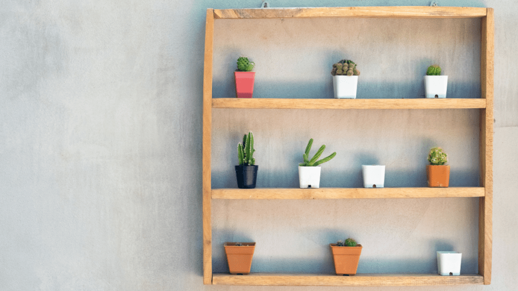 nicho de parede com três andares, cheio de vasos de flores e outros itens decorativos