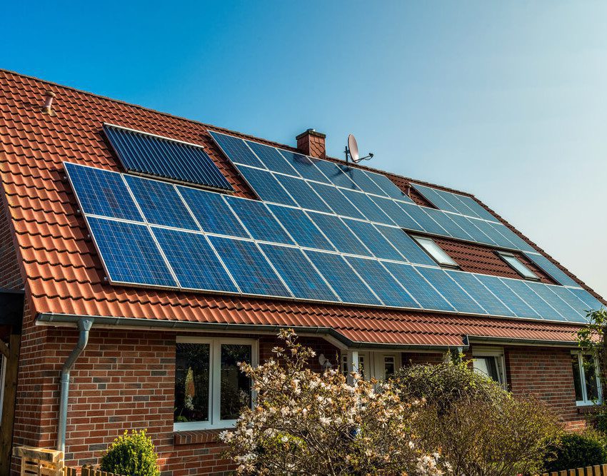 Foto que ilustra matéria sobre casas sustentáveis mostra uma casa vista de lado, com detalhe para o seu telhado quase que totalmente coberto por painéis de captação da luz solar para transformação em energia fotovoltaica.