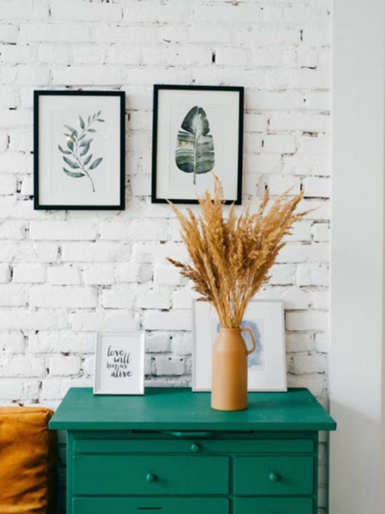 sala minimalista com móvel azul esverdeado e planta em cima