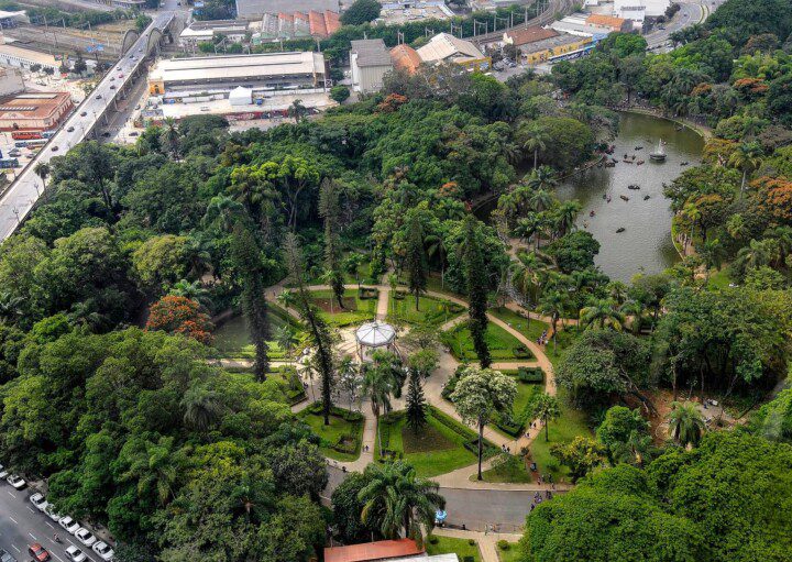 Foto que ilustra matéria sobre os parques em Belo Horizonte mostra uma visão aérea do Parque Municipal Américo Renné Giannetti, com um lago e um coreto cercados por muitas árvores.