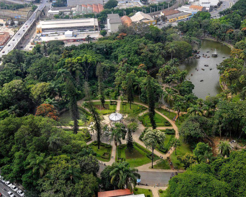 Foto que ilustra matéria sobre os parques em Belo Horizonte mostra uma visão aérea do Parque Municipal Américo Renné Giannetti, com um lago e um coreto cercados por muitas árvores.