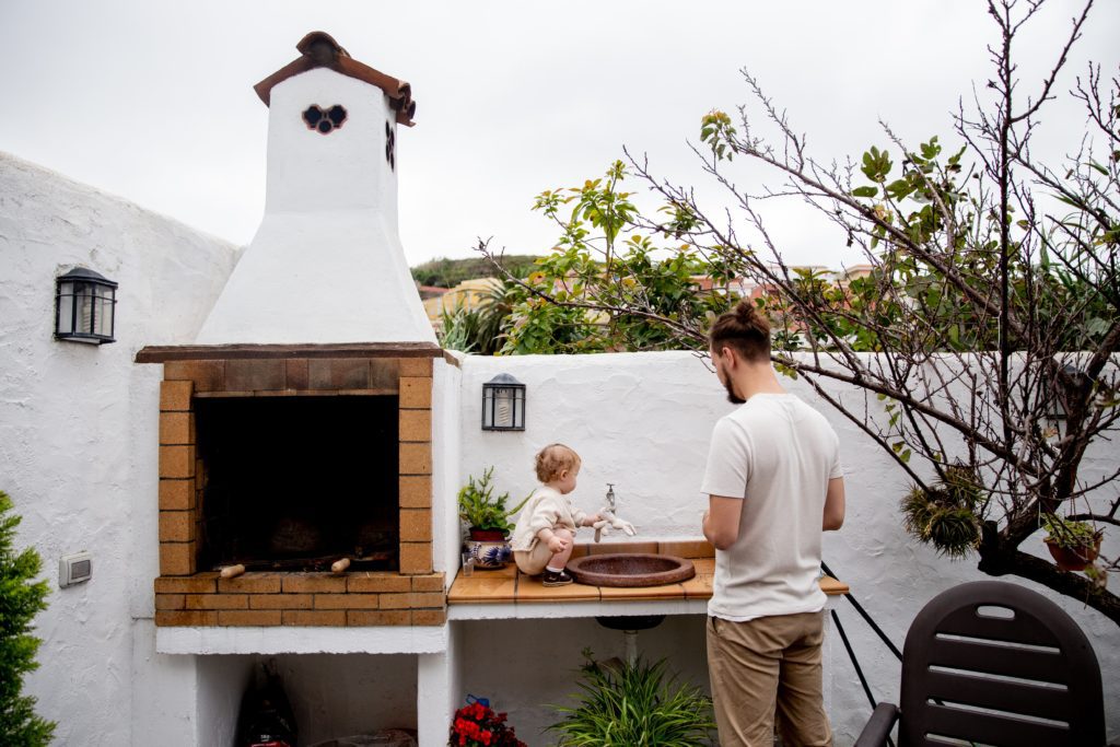 Imagem de churrasqueira de alvenaria com pai e filho cozinhando. Foto disponível no Pexels