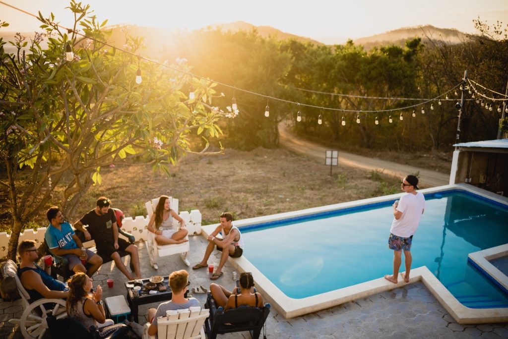 Iluminação com varal de luzes em cima de quintal com piscina. Foto disponível no Unsplash