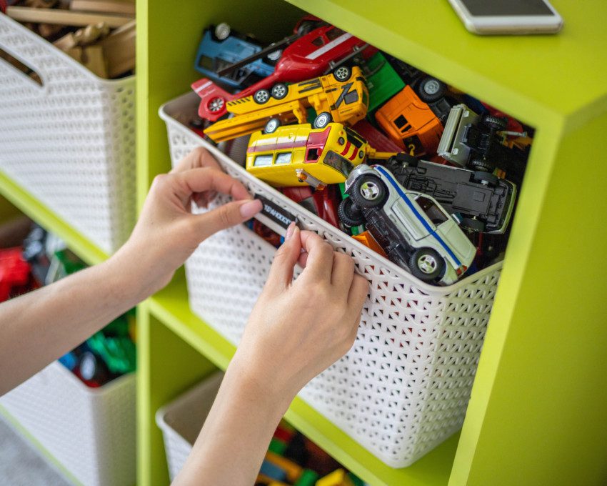 Imagem de um cesto de organização com carrinhos de brinquedo dentro.