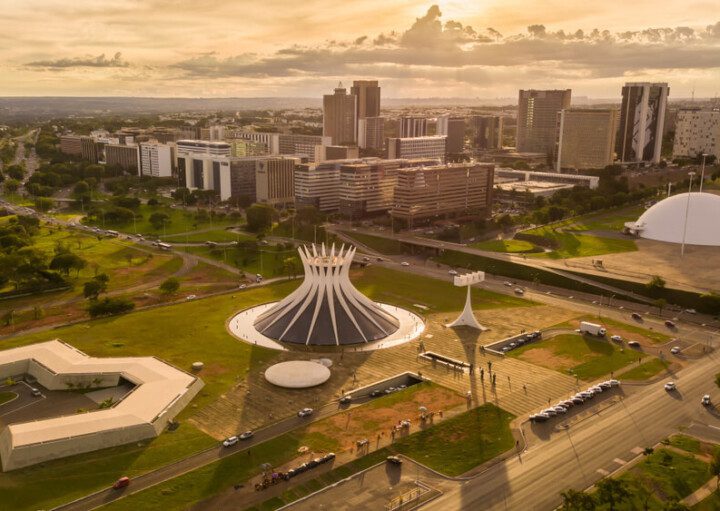 Foto que ilustra matéria sobre moradia no Brasil mostra a cidade de Brasília vista do alto ao entardecer.