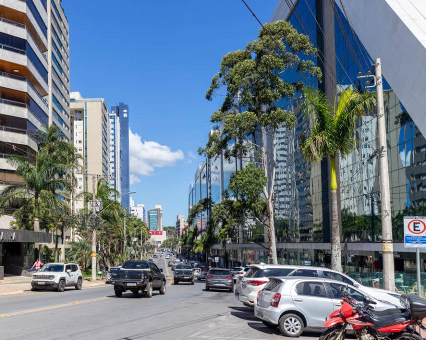 Foto que ilustra matéria sobre o que fazer em Nova Lima mostra uma avenida movimentada do bairro Vila da Serra, onde aparecem prédios grandes e carros.