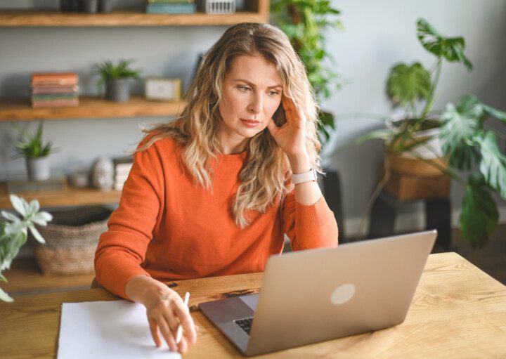 Foto que ilustra matéria sobre inquilino inadimplente mostra uma mulher sentada em frente ao computador.