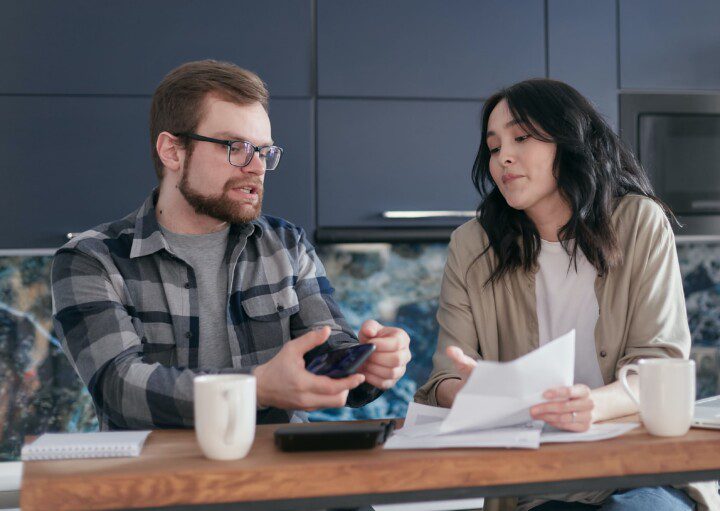 Homem e uma mulher realização uma negociação na mesa de um café. Imagem disponível em Pexels.