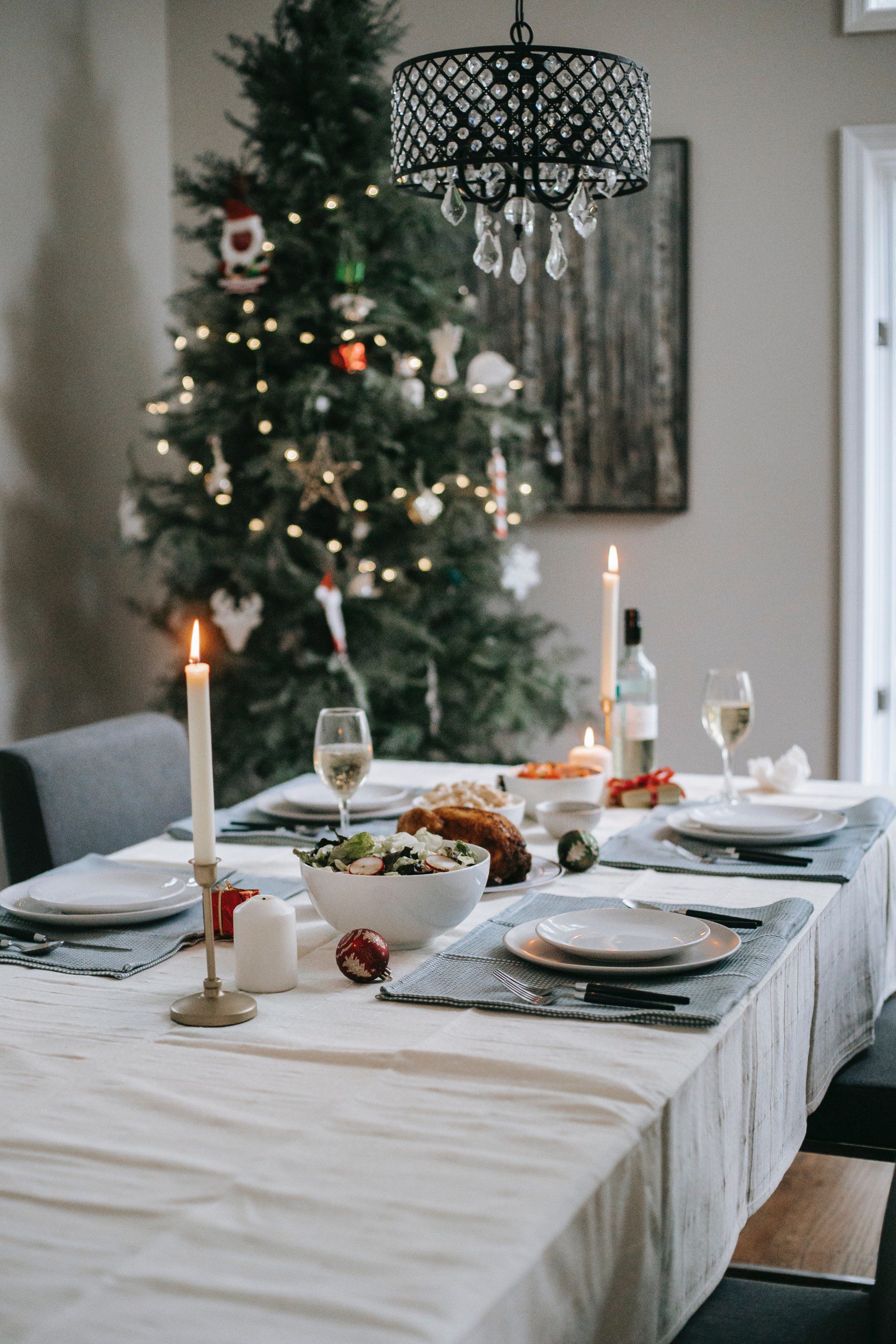 Mesa de Natal clássica com árvore com enfeites natalinos de fundo.