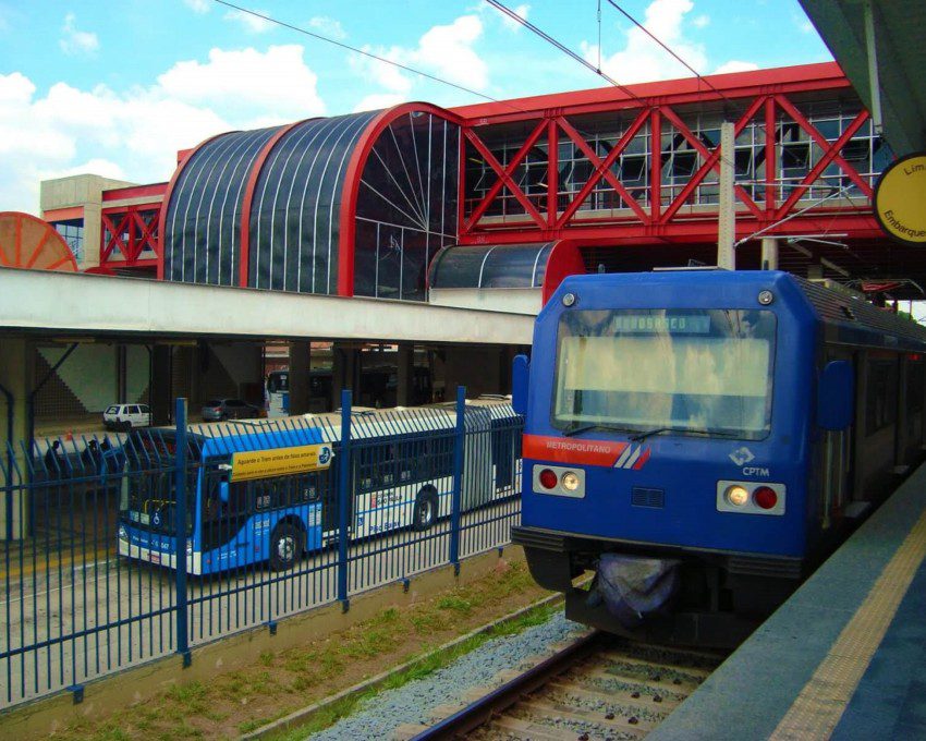 Foto que ilustra matéria do Terminal Grajaú mostra, lado a lado, plataformas de ônibus (à esquerda da imagem) e de trem da CPTM. Acima delas, há uma estrutura vermelha de passarela.