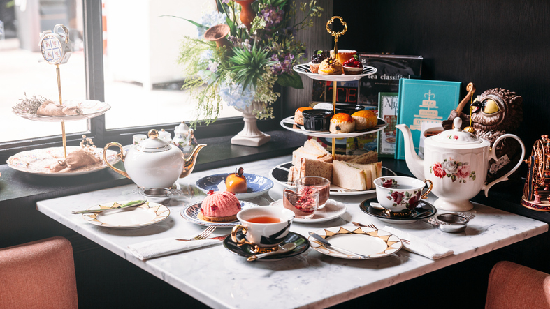 Mesa posta com bebidas, salgados e porcelanas brancas para um chá da tarde,