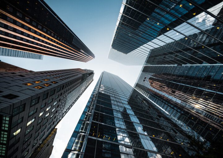 A foto mostra vários prédios grandes vistos de baixo para cima.