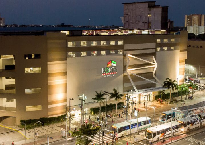 Foto que ilustra matéria sobre shoppings em Fortaleza mostra a fachada do North Shopping à noite vista de cima.