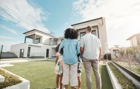 Consórcio ou financiamento: foto de uma família em uma casa nova