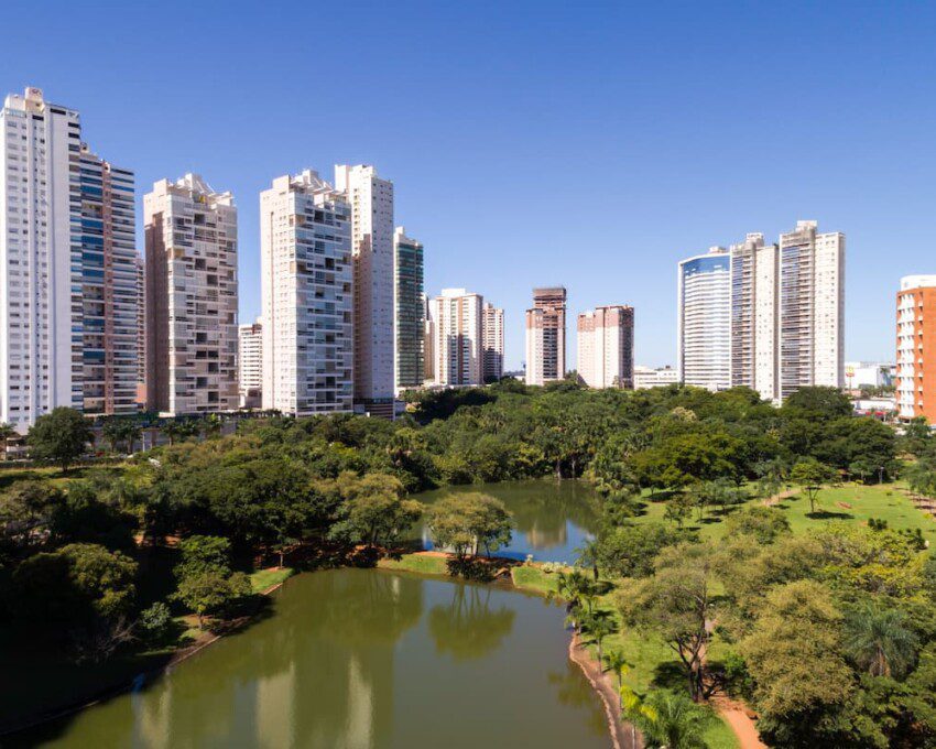 Parque Flamboyant com prédios ao fundo.