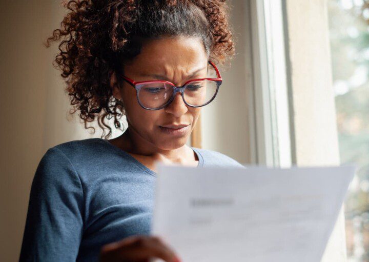 Mulher ler com preocupação um documento.