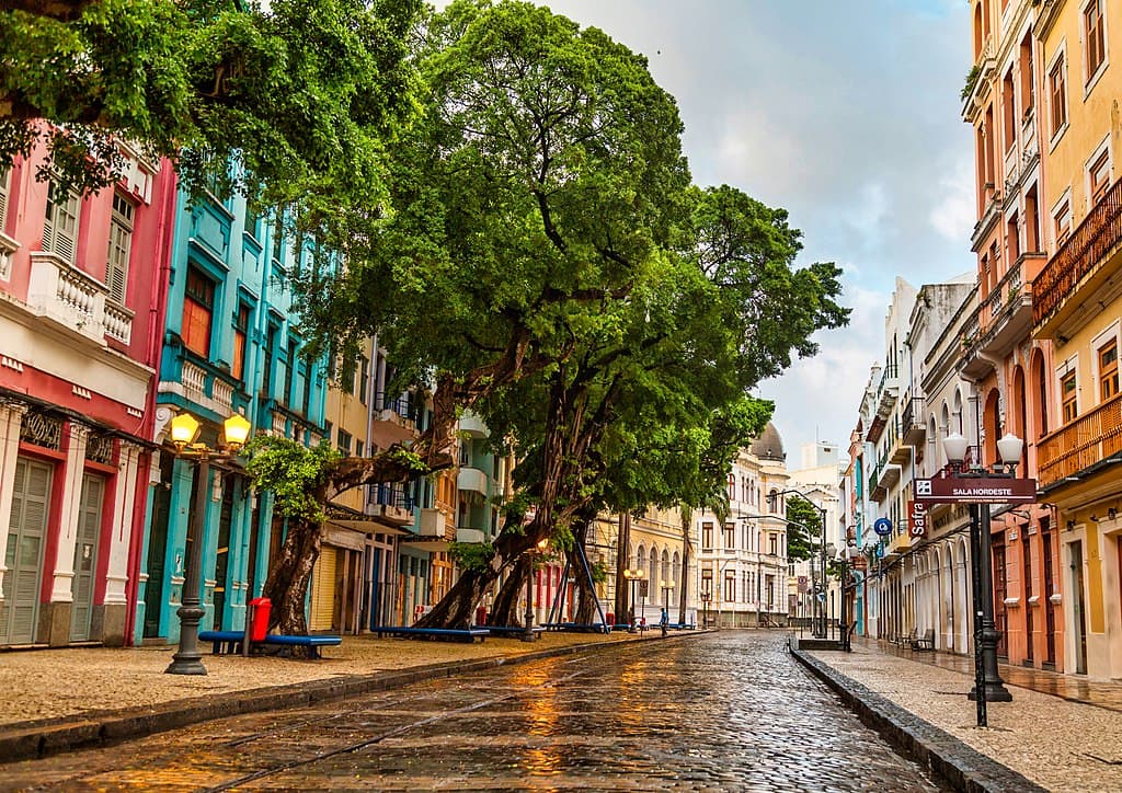 Imagem da Rua do Bom Jesus, com céu aberto e azul, edifícios coloridos e árvores.