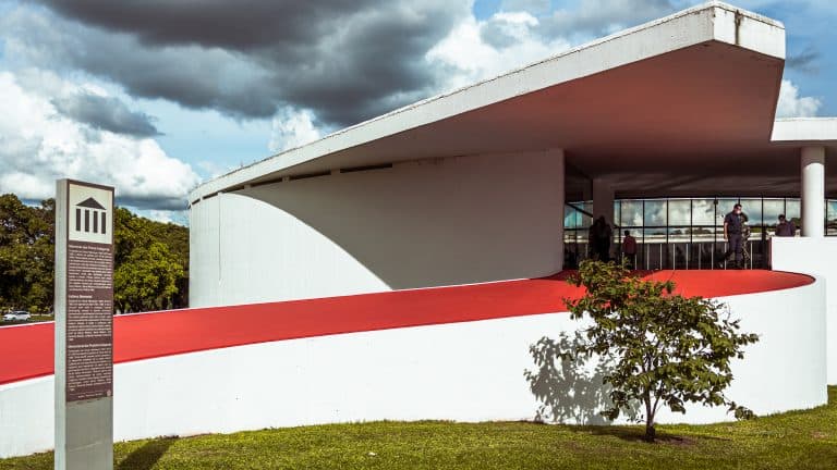 Memorial dos Povos Indígenas. Um monumento branco, com muitas curvas e uma rampa vermelha.