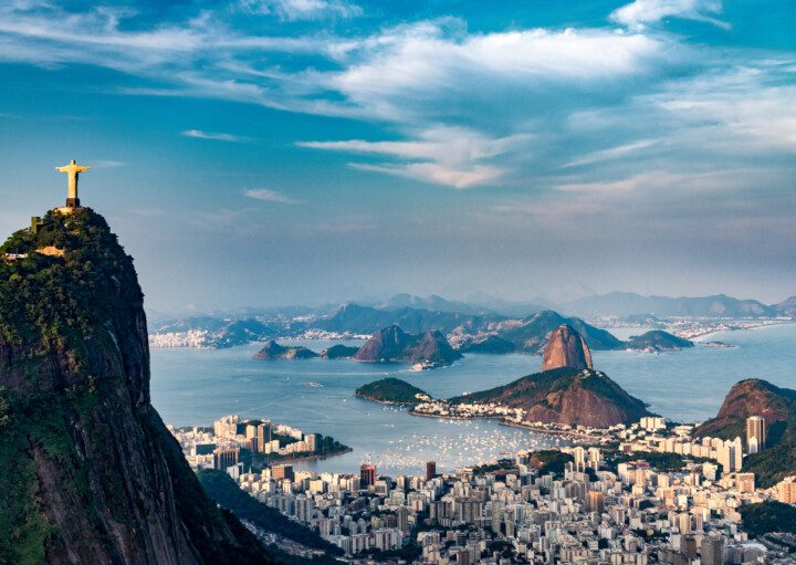 Imagem da vista aérea do Morro do Corcovado que mostra parte dos prédios, morros e praias do Rio de Janeiro