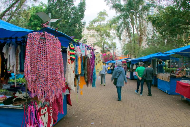 Imagem de várias barracas da Feira Hippie de Campinas com peças em crochê, artesanato a alimentação. 