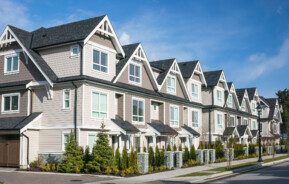 Imagem panorâmica de um conjunto de townhouses modernas com fachadas na cor bege e marrom