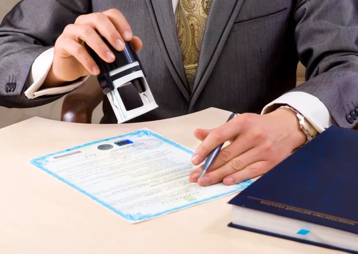 Um homem que, provavelmente, trabalha em um cartório, carimba uma procuração para venda de imóveis.