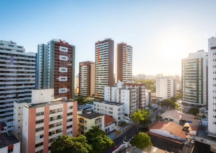 Imagem panorâmica de prédios de diversas alturas e cores em um dia ensolarado para ilustrar matéria sobre quanto custa um apartamento de 2 quartos