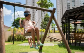 Uma menina brinca na área de lazer de um condomínio.