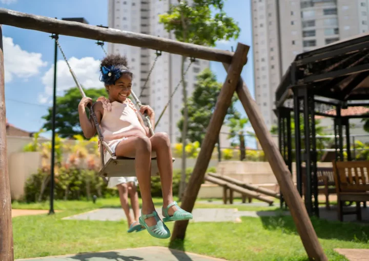 Uma menina brinca na área de lazer de um condomínio.