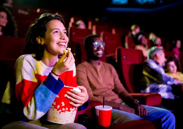 Pessoas se divertem em uma sala de cinema de rua de São Paulo.