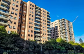 Imagem de três edifícios residenciais com avenidas bem arborizadas e céu azul para ilustrar matéria sobre como escolher o andar do apartamento