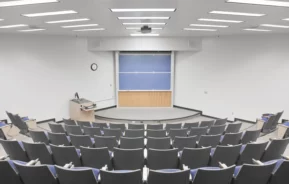 Imagem de sala de aula moderna com mesas, cadeiras e lousa para ilustrar matéria sobre faculdades em Florianópolis