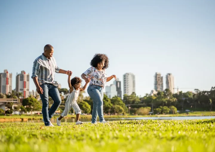 Imagem de uma família feliz se divertindo em uma cidade com bom IDH.