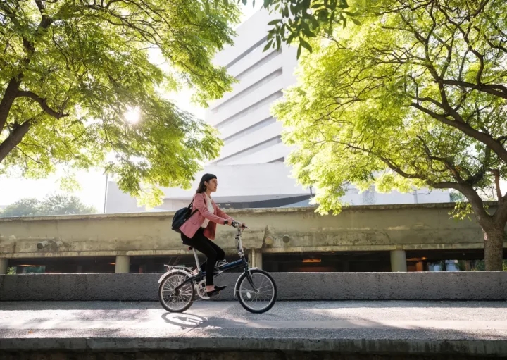 Uma mulher andando de bicicleta em uma cidade sustentável.