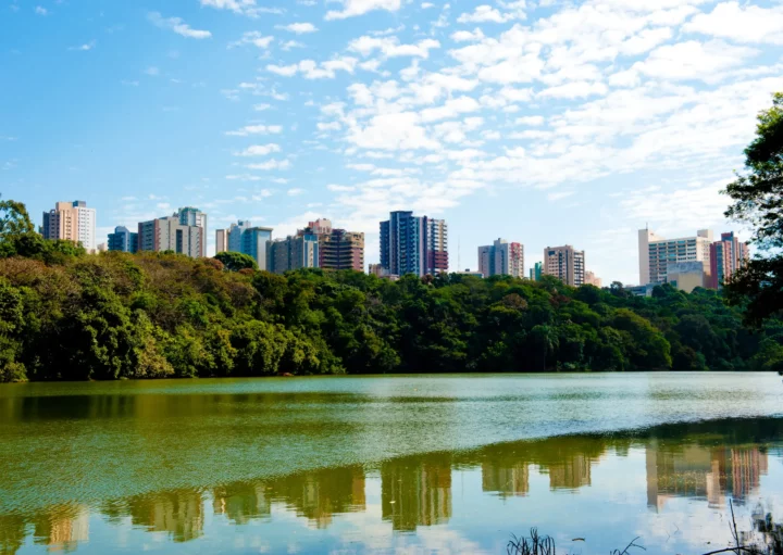 Foto de um parque de Maringá com prédios ao fundo.