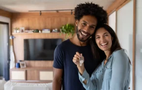 Foto de um casal feliz segurando a chave da casa nova.