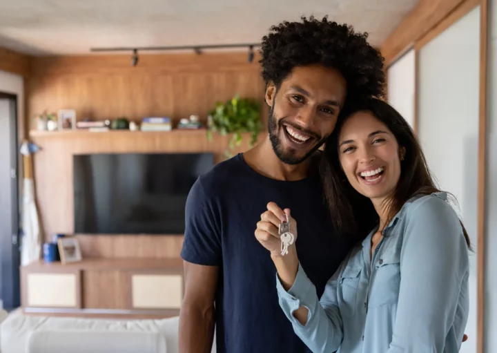 Foto de um casal feliz segurando a chave da casa nova.