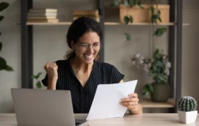 Imagem de uma mulher recebendo uma notícia boa em um contrato para ilustrar matéria sobre: "fui contemplado no consórcio, preciso comprovar renda?"