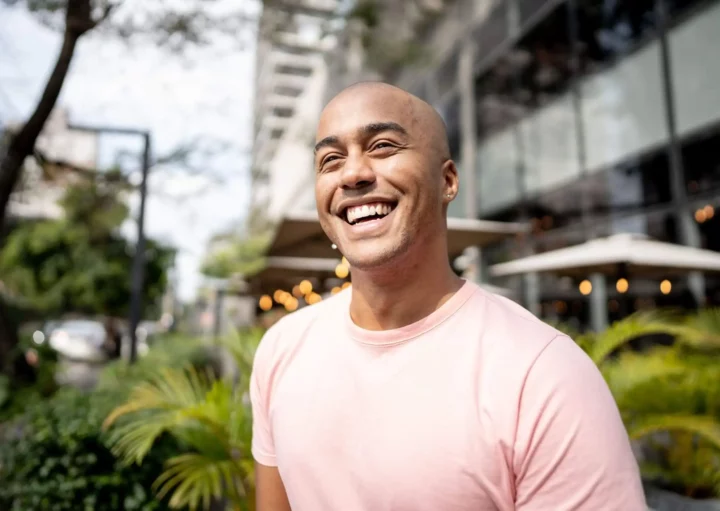 magem de um homem feliz no meio de uma cidade para ilustrar matéria sobre qual a cidade mais segura de Minas Gerais