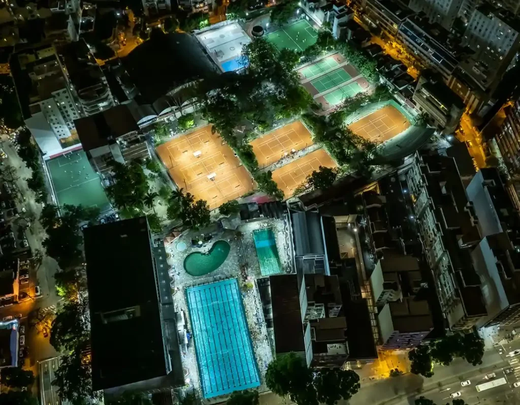 Foto que ilustra matéria sobre clubes no Rio de Janeiro mostra uma vista do alto das quadras e da piscina do Tijuca Tênis Clube iluminadas à noite (Foto: Divulgação)