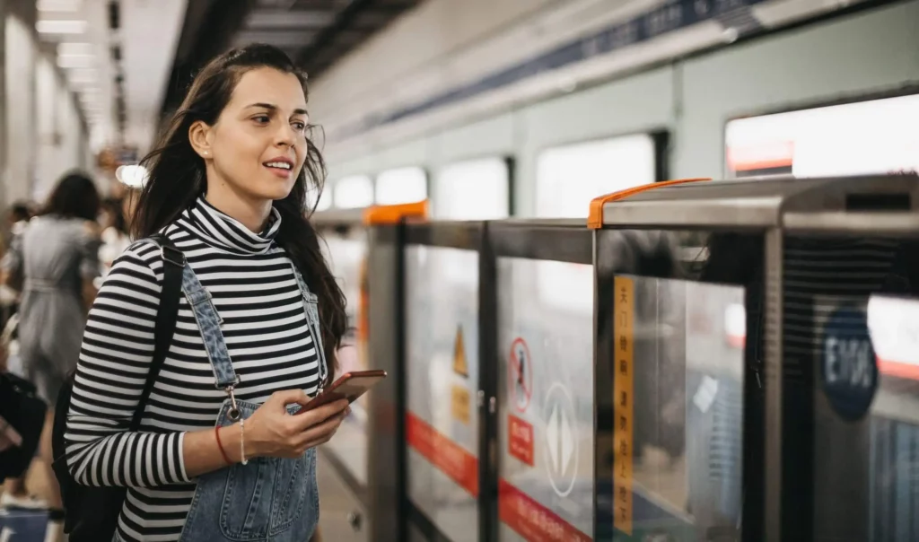 Imagem de uma mulher em uma estação de metrô esperando o trem para embarcar para ilustrar matéria sobre estação da Linha Verde