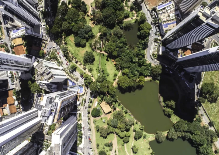 Imagem da vista superior de Goiânia mostra Parque Flamboyant e prédios ao redor para ilustrar matéria sobre os bairros mais populosos de Goiânia