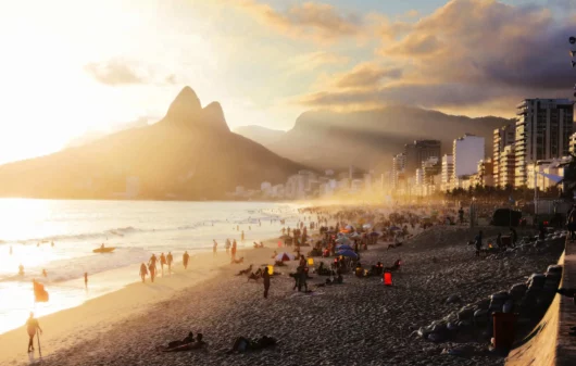 Imagem de pessoas aproveitando a praia de Ipanema em um dia de sol para ilustrar matéria sobre os bairros mais quentes do Rio de Janeiro