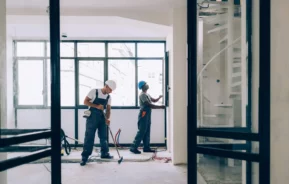 Imagem de dois homens trabalhando na manutenção no interior de uma casa para ilustrar matéria sobre como cuidar de imóvel alugado