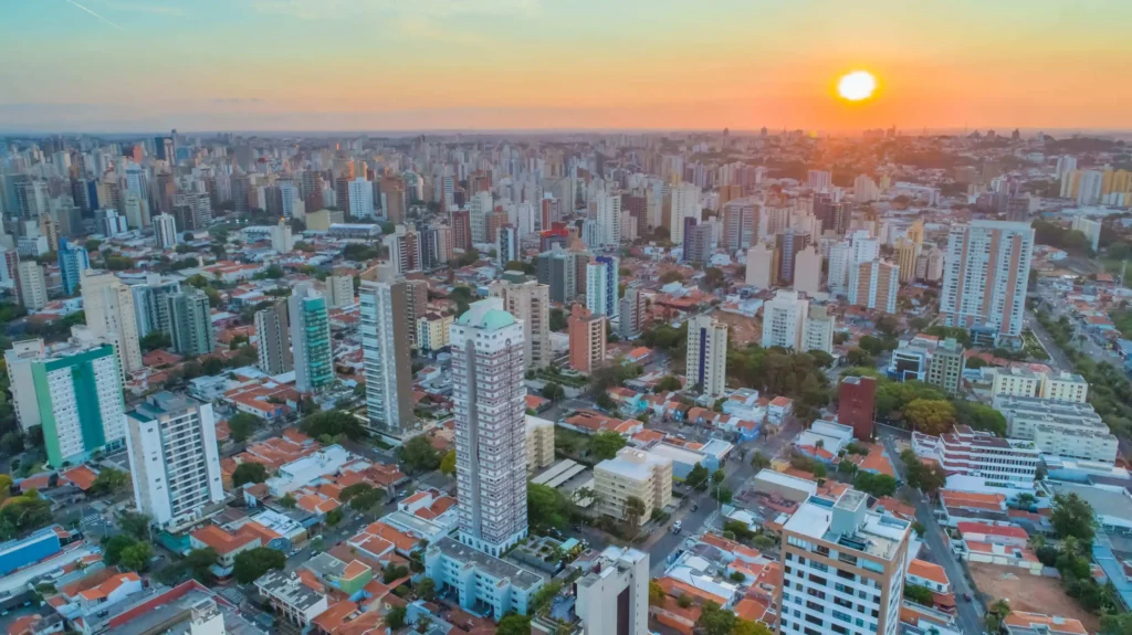 Imagem do pôr do sol em Campinas mostra prédios da cidade para ilustrar matéria sobre os bairros com mais moradores em Campinas